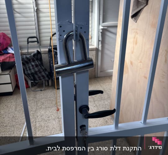 מנעול תלוי על דלת מתכת עם ידית ומפתח